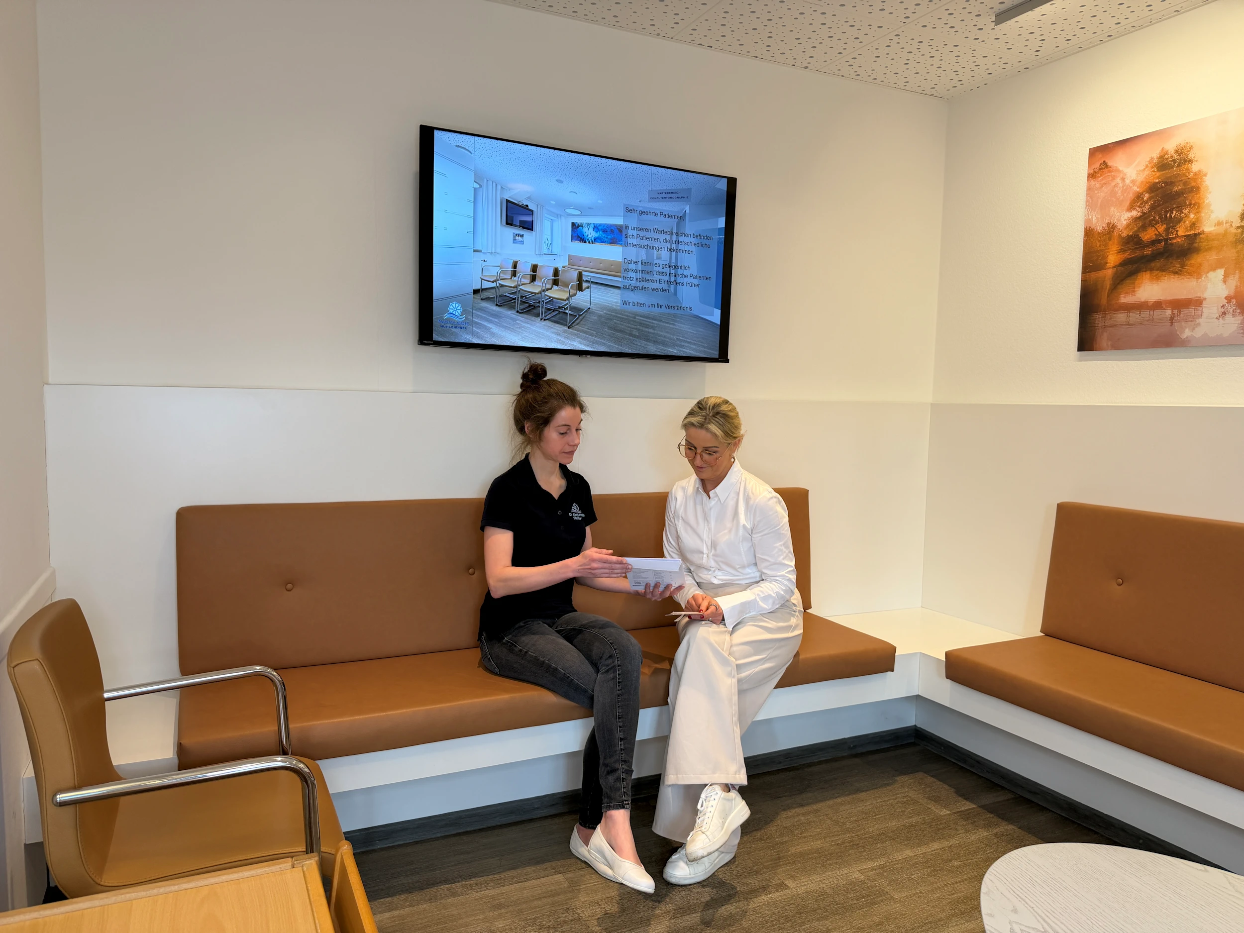 Radiologie Mühleninsel: Patientin und Ärztin im Gespräch im Wartezimmer. sitzend vor dem radiologie screen. sie besprechen die befunde MRT BEcken